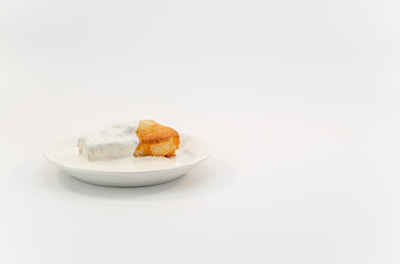 dolcetto in soffice pan di spagna con crema in piattino su sfondo bianco