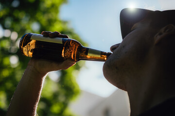 Man trinkt Bier aus Flasche im Sommer