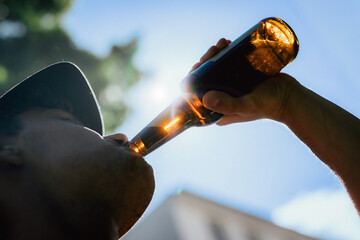 Man trinkt Bier aus Flasche im Sommer