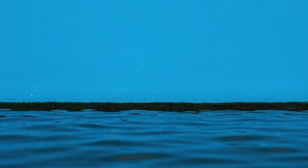 Tranquil water surface reflecting a clear blue sky with subtle ripples