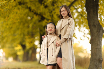 Family day, mother's day. Happy smiling young mom soft huggs her adorable child daughter, spend...