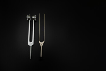 tuning fork C 128 on a black background with gradation and otorhinoscope and neurological hammer