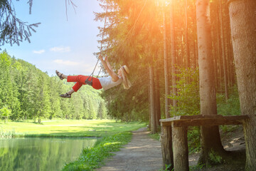 Woman Enjoying Nature on a Swing. Embraces lightness and freedom, surrounded by fresh air and greenery. Relaxation, happiness, connection to nature	