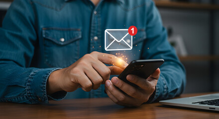 Close Up Of a Man In Blue Shirt Using Smartphone with Message Notification on Wooden Desk with Laptop