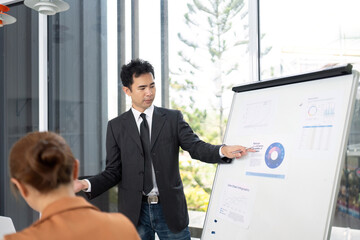 Obraz premium Business Presentation in Progress. Professional man explaining data to colleagues in a modern office.