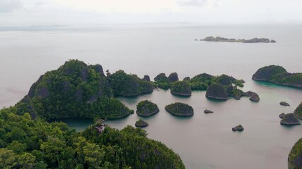 Raja Ampat, Indonesia: Aerial drone footage of the famous Piaynemo viewpoint plateform overlooking a stunning lagoon in the Fam islands in Raja Ampat in west Papua in Indonesia. - Powered by Adobe