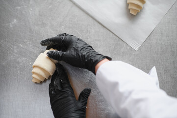 Fototapeta premium Baker making croissant dough in bakery kitchen