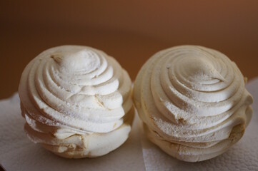 White marshmallows on a brown background.