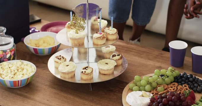 Enjoying snacks, diverse hands reaching for grapes and pretzels at family gathering, at homd