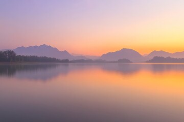 Naklejka premium A serene lake at sunset with mountains in the background