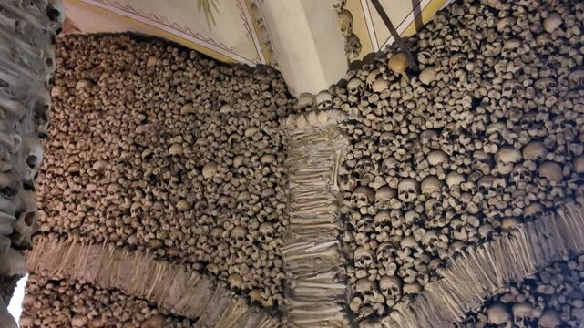 Human skulls and bones decorating the interior of the Chapel of Bones in Evora, Portugal, creating a macabre and historical landmark