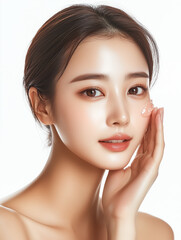 Fototapeta premium Korean woman applying skincare product with a natural, glowing look in a bright, minimalist studio