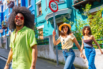 Happy tourists walking on a colorful street during summer vacation
