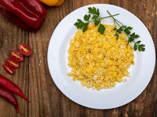 fresh scrambled eggs on white plate on breakfast table