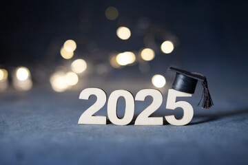 Class of 2025 concept. Wooden number 2025 with graduation hat with bokeh