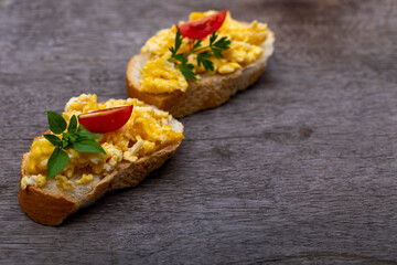 Scrambled eggs, delicious breakfast with herbs and tomatoes