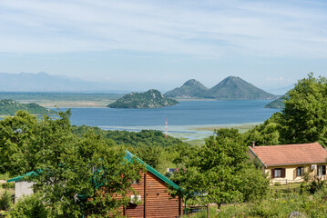 Landscape of blue deep lake, clouds in sky, mountains Skadar lake Montenegro