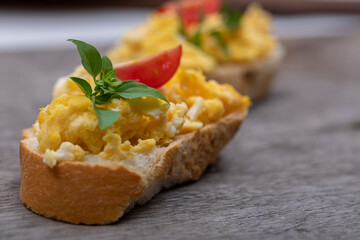Scrambled eggs, delicious breakfast with herbs and tomatoes