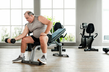 Overweight man lifting dumbbell in gym, focused on weight training to burn fat and improve health. Promotes fitness, body strength, and wellness through consistent fat-loss and exercise routines.