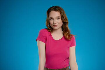 Woman exudes confidence and emotion while posing against a bright blue studio backdrop during a...