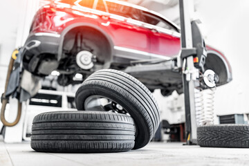 Fototapeta na wymiar Car tires pile in garage service center or shop. Concept maintenance of auto, background with sunlight