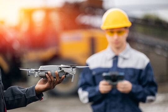 Closeup Uav drone technology in sand quarry, monitoring mining operations with surveying engineer
