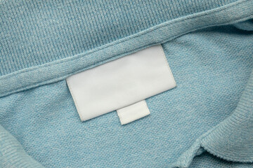 White blank laundry care clothes label on shirt fabric background