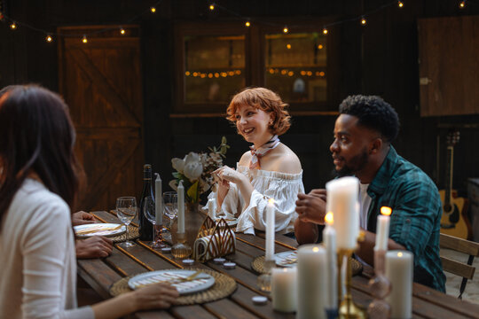 A group of friends having an outdoors dinner party