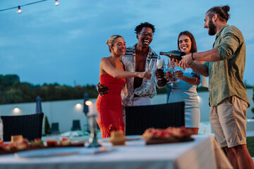 Friends pouring sparkling wine at a luxury resort party