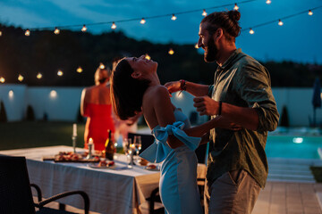 Couple dancing at a night party in the backyard