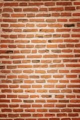 Texture of weathered brown brick wall with vignette.