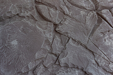 The wall features a detailed surface resembling natural stone with a neutral color palette. The...