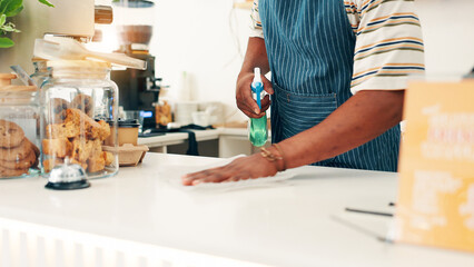 Hands, cleaning countertop and man in cafe, spray bottle and disinfectant with maintenance. Closeup, employee compliance or person in coffee shop, safety policy or cloth to remove bacteria or hygiene