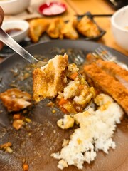 Delicious Bite of Crispy Chicken with Rice and Vegetables on a Plate in a Cozy Restaurant Setting
