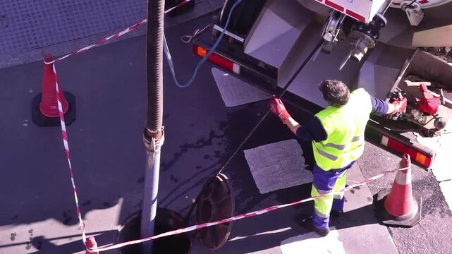 sewer truck with sewage utility worker to cleaning the drain line in city street , video footage  hd