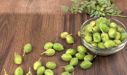 Fresh Green chickpeas on a branch, and in the pod, isolated on wooden background.