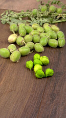 Fresh Green chickpeas on a branch, and in the pod, isolated on wooden background.