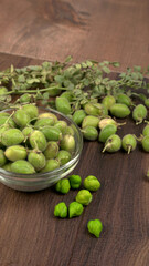 Fresh Green chickpeas on a branch, and in the pod, isolated on wooden background.
