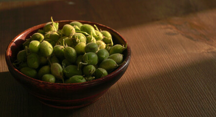 Fresh Green chickpeas on a branch, and in the pod, isolated on wooden background.