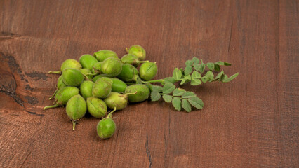 Fresh Green chickpeas on a branch, and in the pod, isolated on wooden background.