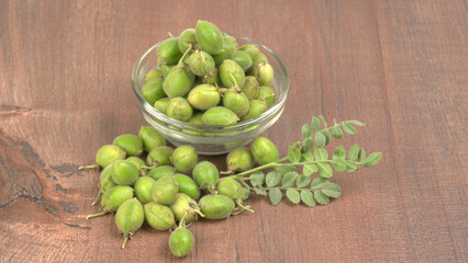 Fresh Green chickpeas on a branch, and in the pod, isolated on wooden background.