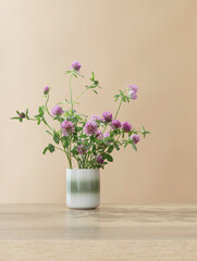 still life with clover  in ceramic cup  on wooden table