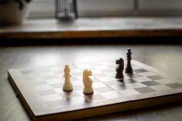 White chess knight piece and other pieces on chessboard during the game