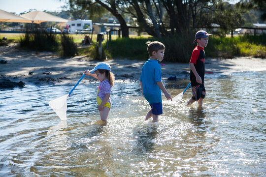 Three kids playing where the river meets the sea