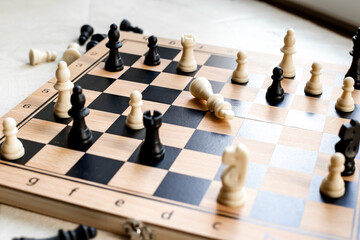 White chess king laying down on chessboard after checkmate