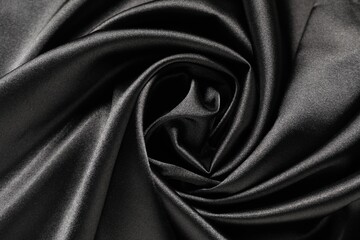 Black crumpled silk fabric as background, top view