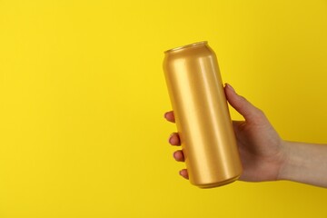 Woman with tin can on yellow background, closeup. Space for text