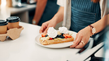 Hands, serving and waitress with breakfast in cafe for order, help or customer service at counter. Food, nutrition and closeup of barista with waffles, fruit and cream for morning meal in coffee shop