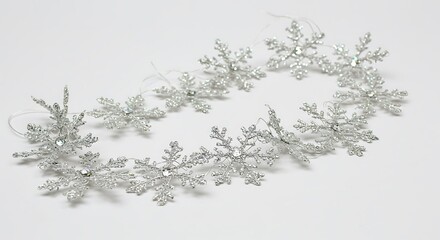 Fototapeta premium Sparkling silver snowflakes elegantly arranged create a festive winter garland.. AI Generated
