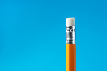 Pencil with eraser on light blue background, closeup. Space for text